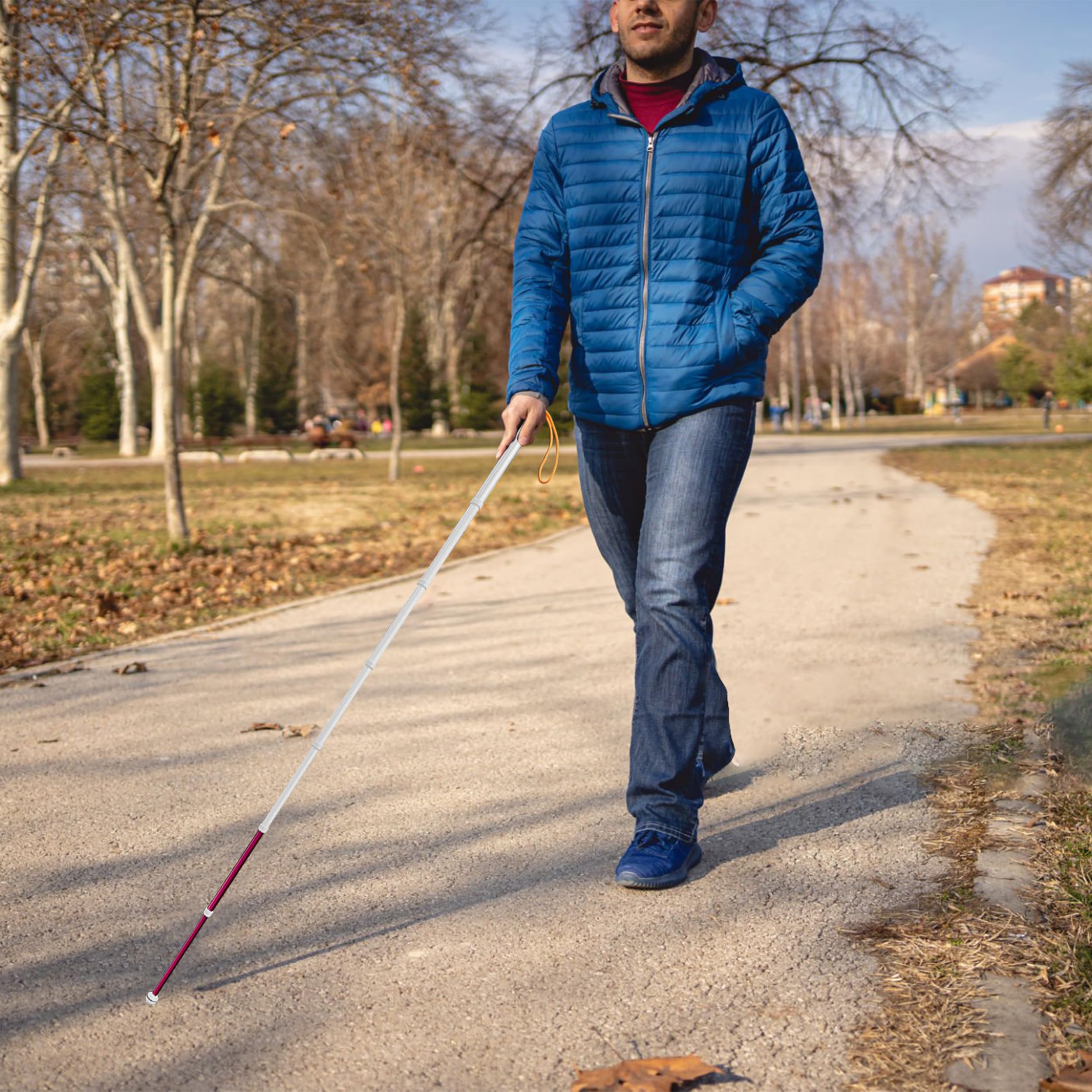 Man walking in public park with fully extended telescopic blind cane for daily travel